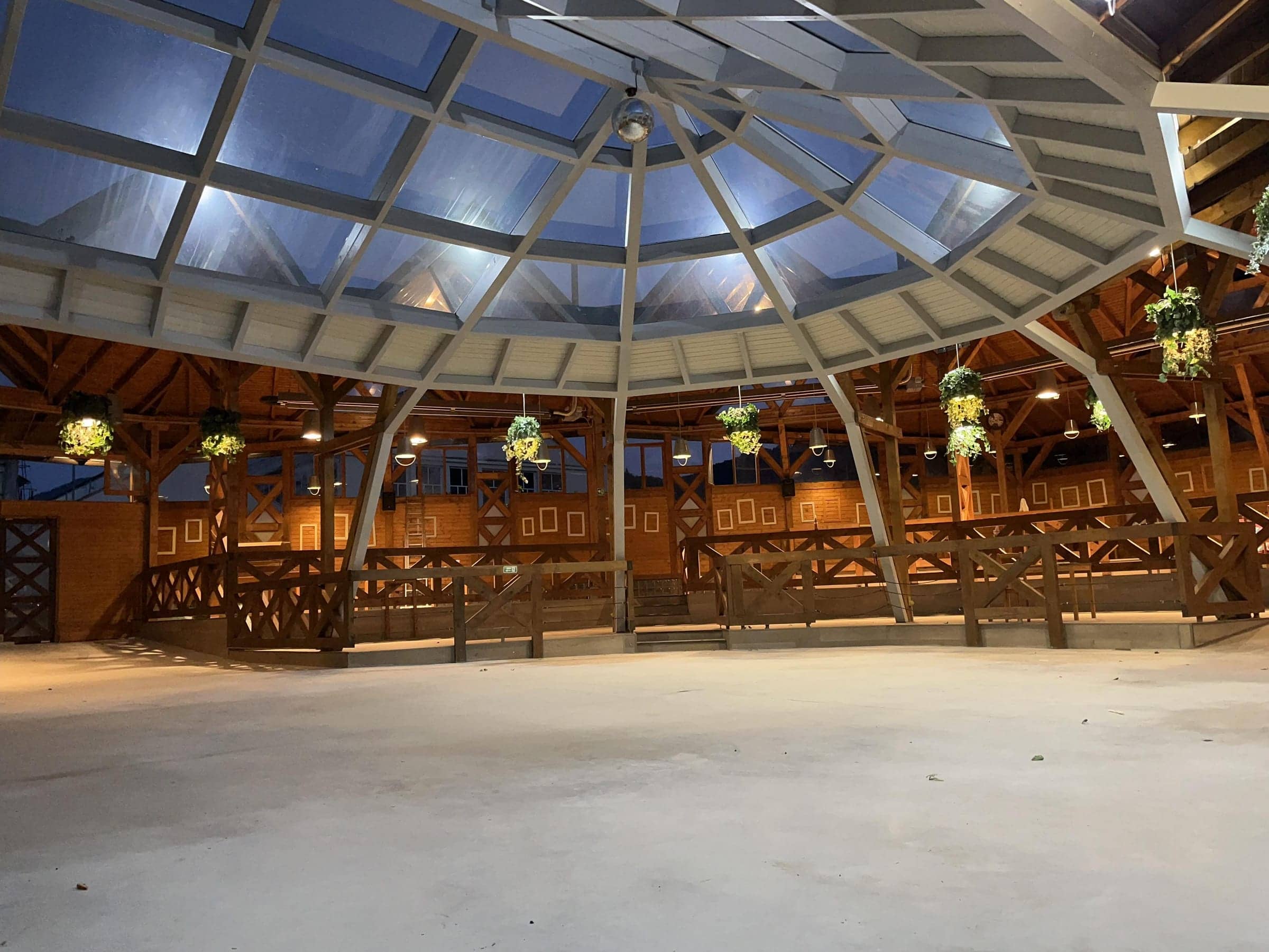 Interiorul foișorului seara, cu cupola de sticlă luminată și ringul de dans liber