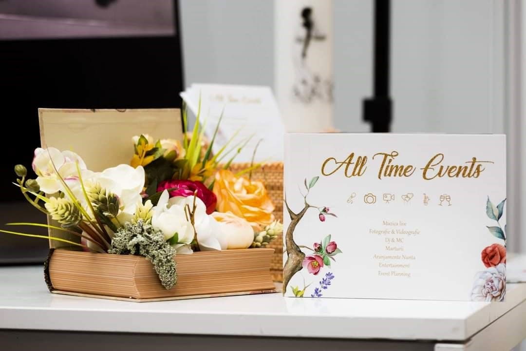Cardul de servicii All Time Events, așezat lângă un aranjament floral