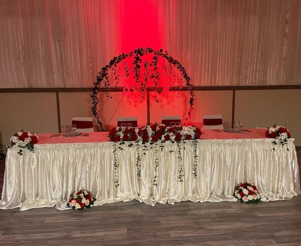 Masa prezidiului decorată în roșu și ivory, cu arcadă de iederă și uplighting roșu